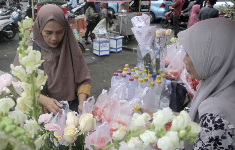 Penjual bunga tabur melayani pembeli di TPU Karet Bivak, Jakarta, Minggu (3/3).(Sinar Harapan/Oke Atmaja)