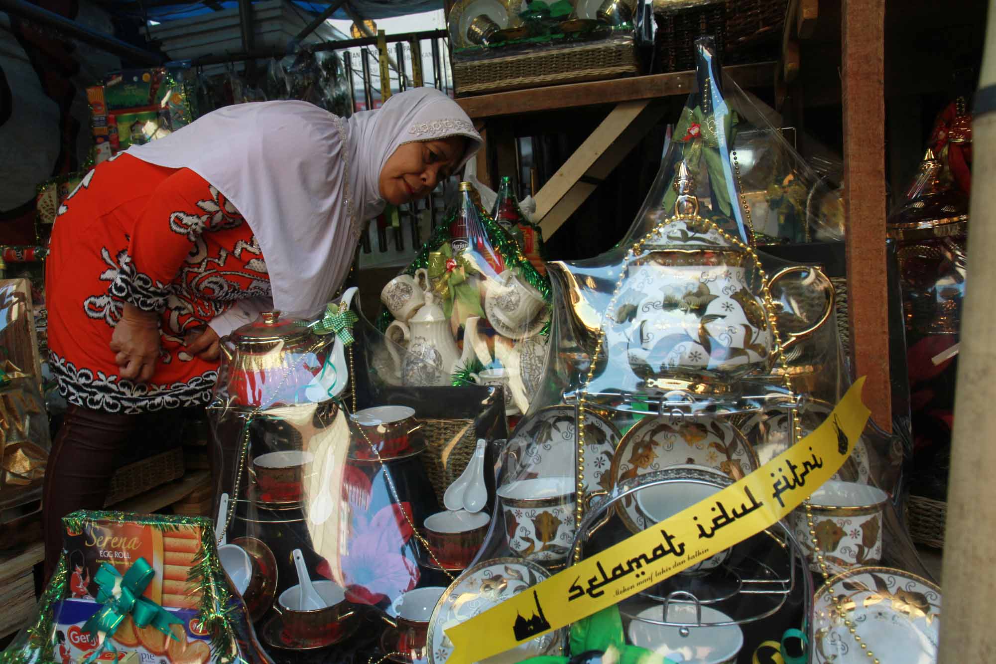 Pedagang menyelesaikan pembuatan parsel Lebaran berisi produk makanan ringan di Pasar Kembang, Cikini, Jakarta, Rabu (22/3/2024). (IndonesiaGlobe/Oke Atmaja)