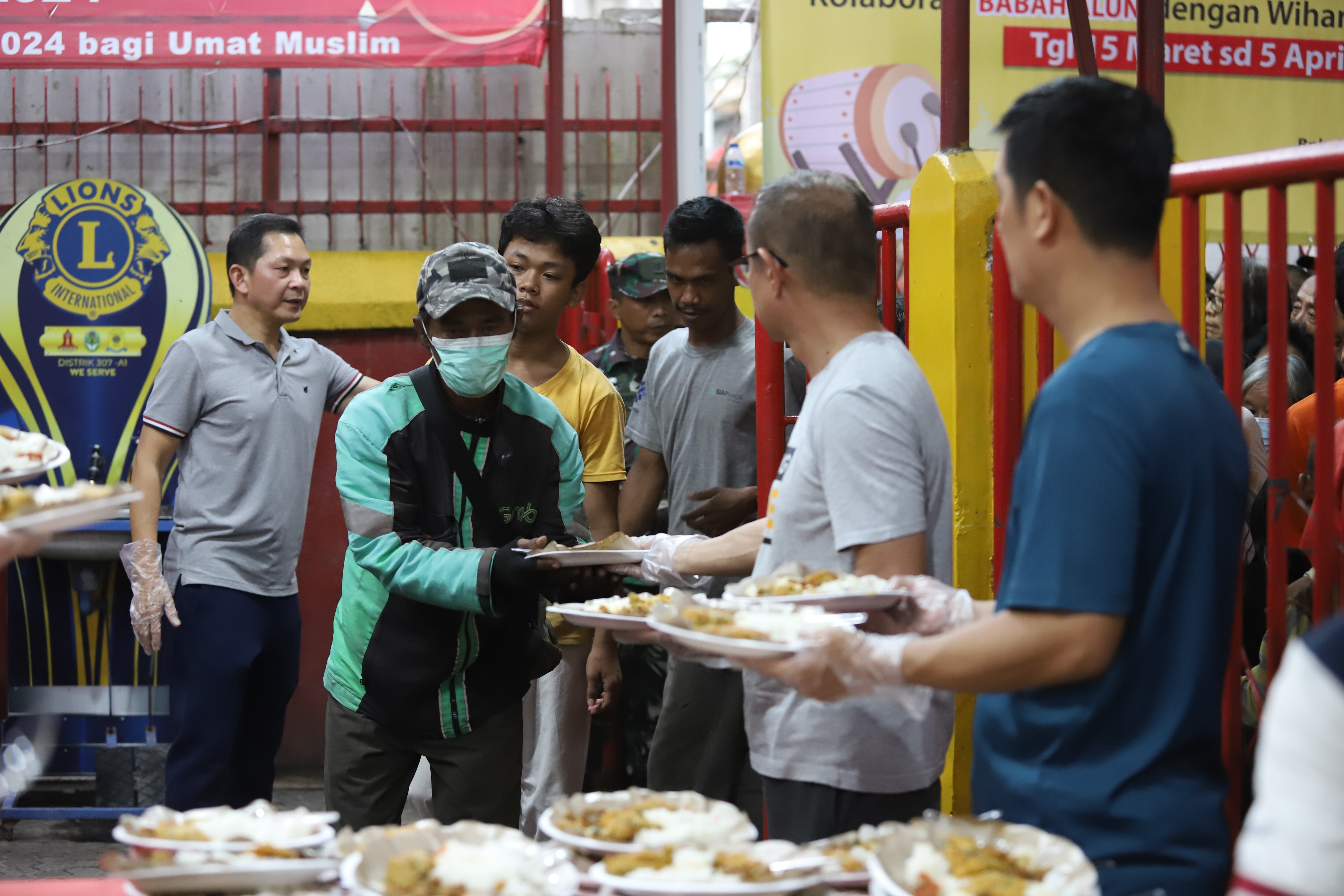 Warga antre mengambil makanan untuk berbuka puasa di Vihara Dharma Bakti, Petak Sembilan, Jakarta, Senin (19/3).(Indonesiaglobe/Oke Atmaja)