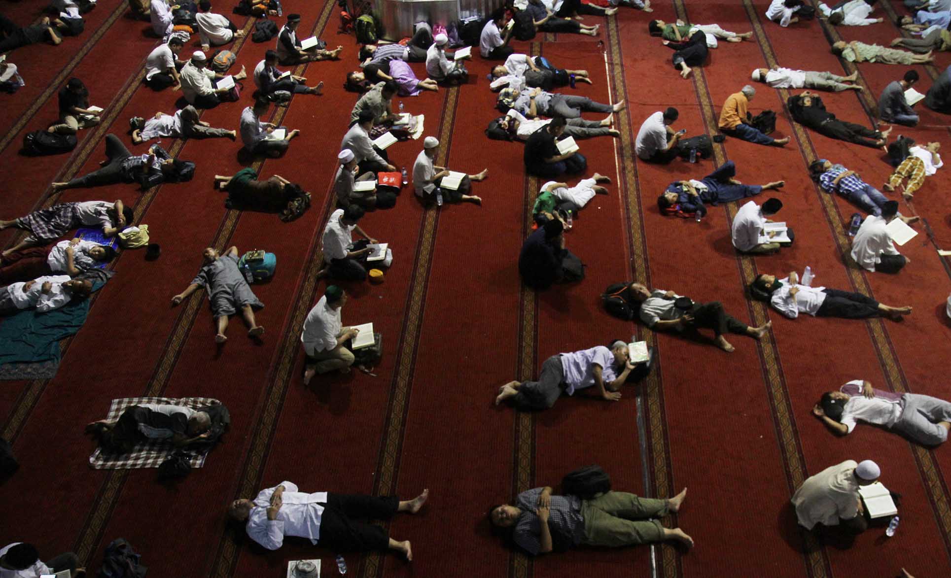 Umat muslim membaca Alquran dan sebagian lagi beristirahat ketika beritikaf di Masjid Istiqlal, Jakarta, Jumat (5/4/2024). (BeritaNasional/Oke Atmaja)