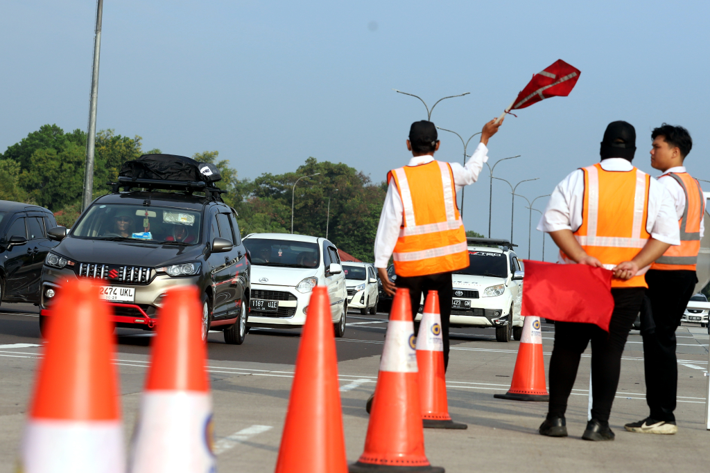 Petugas memberi arah kepada pemudik yang melintas di Tol Cikampek. (BeritaNasional/Elvis Sendouw)