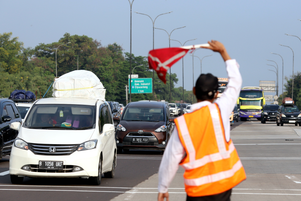 Petugas memberi arah kepada pemudik yang melintas di Tol Cikampek. (BeritaNasional/Elvis Sendouw)