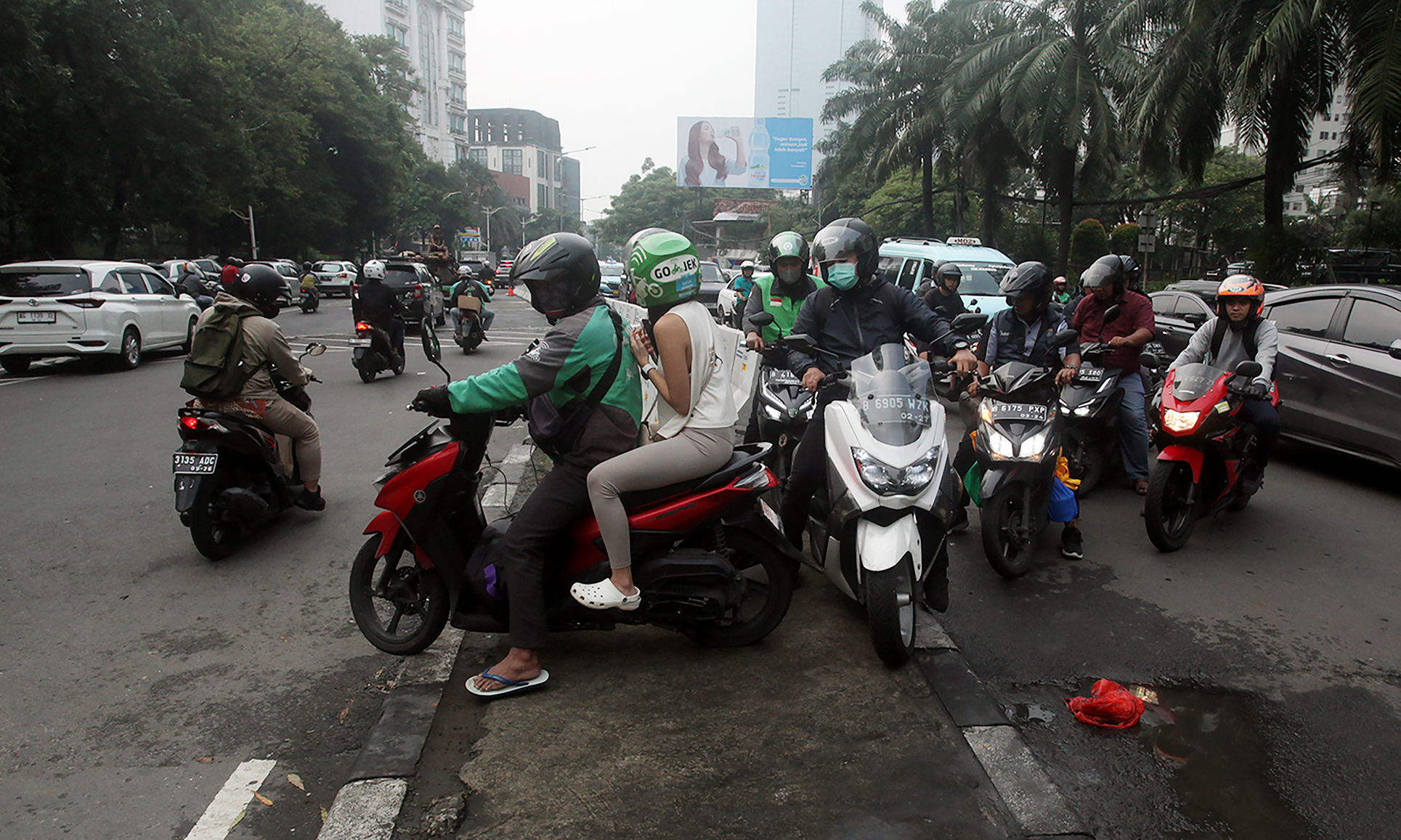 Pengendara sepeda motor mendorong motornya melewati pembatas jalan saat uji coba penutupan putar balik (U-Turn) Citywalk di Jalan KH Mas Mansyur, Karet Tengsin, Jakarta, Selasa (2/4/2024). (Indonesiaglobe/Oke Atmaja)