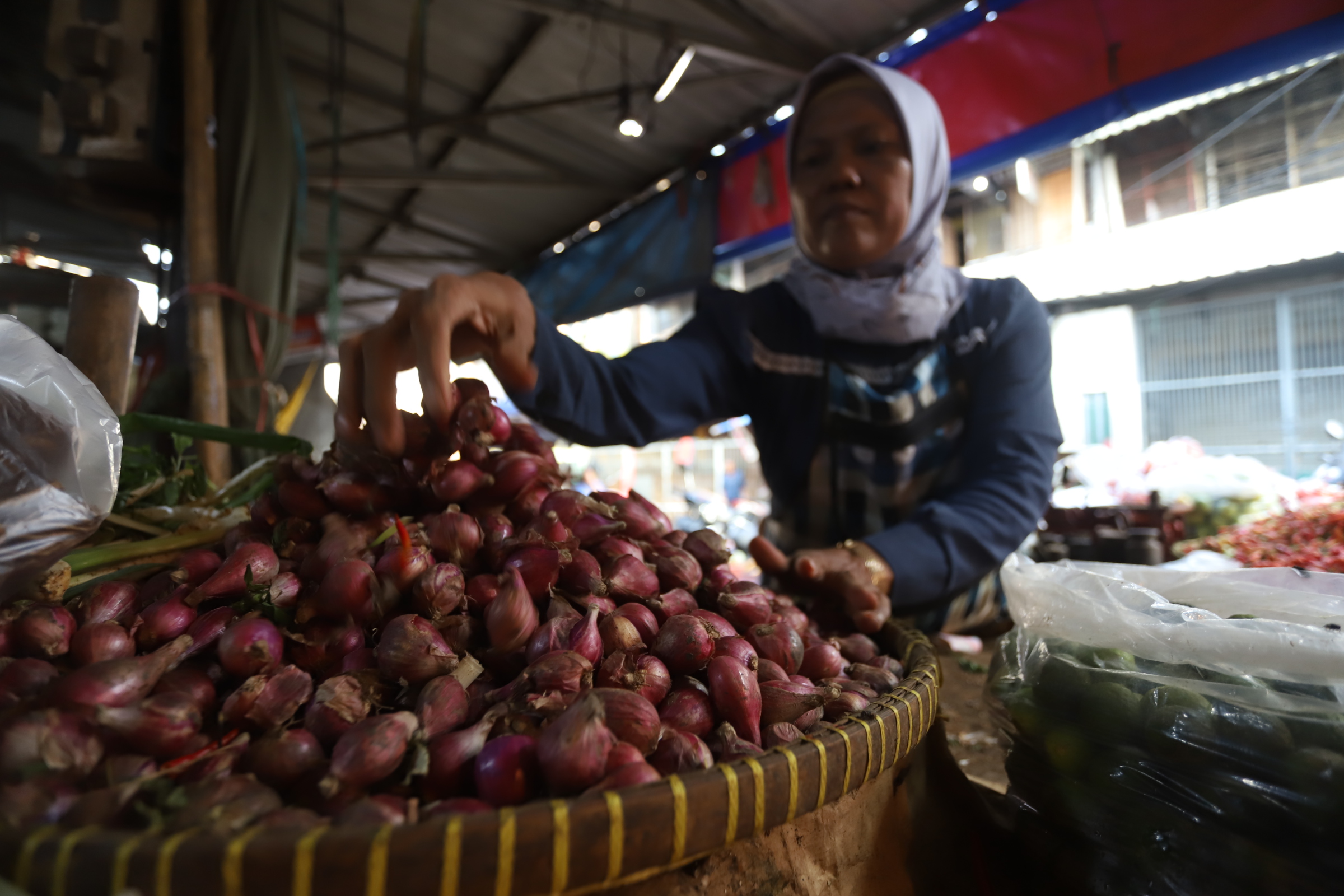 Pedagang menata bawang merah di pasar Kebayoran Lama, Jakarta, Kamis (2/5/2024).  (BeritaNasional.Com/Oke Atmaja)