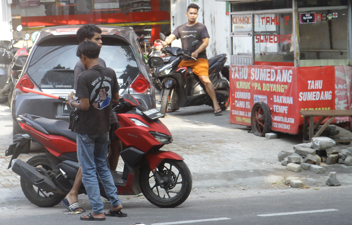 Juru parkir memarkirkan kendaraan di salah satu minimarket di kawasan Jakarta, Senin (13/5/2024).  (BeritaNasional.com/Oke Atmaja)