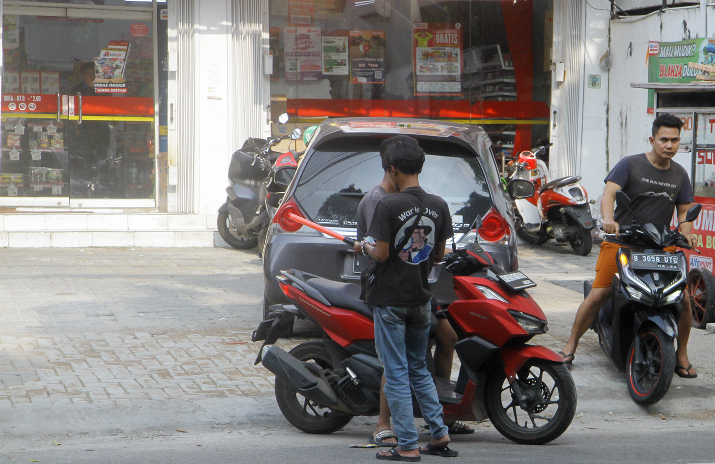 Juru parkir memarkirkan kendaraan di salah satu minimarket di kawasan Jakarta, Senin (13/5/2024). (BeritaNasional.com/Oke Atmaja)