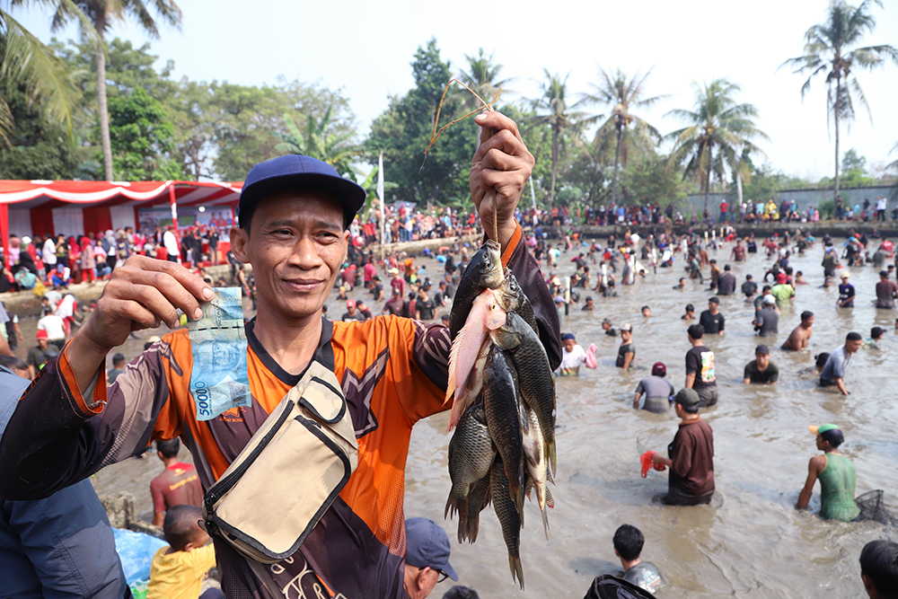 Kecerian warga mengikuti tradisi lebaran Depok "Ngubek Empang" di Cilodong, Depok. (BeritaNasional/Elvis Sendouw)