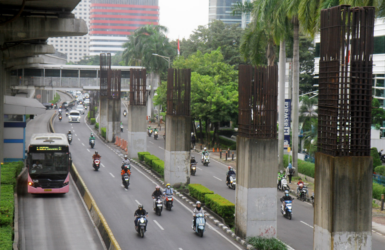 Sejumlah kendaraan melintas di antara tiang monorel yang terhenti pembangunannya di Jalan Rasuna Said, Jakarta, Senin (3/6/2024). (BeritaNasional.Com/Oke Atmaja)