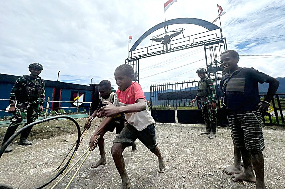 Prajurit Satgas Yonif 509 Kostrad bermai bersama anak-anak Papua. (BeritaNasional/HO/Elvis Sendouw)