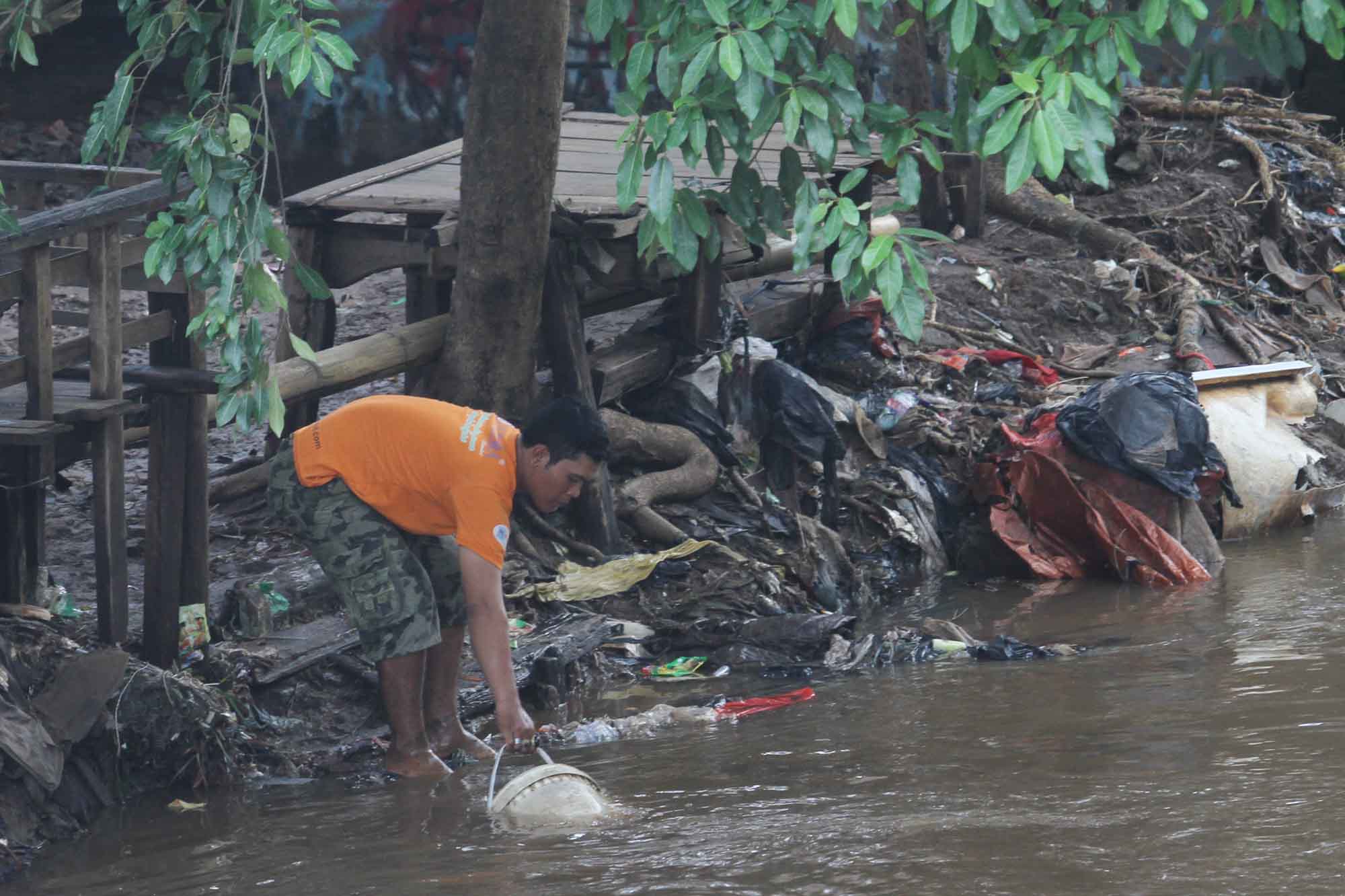 Warga mengambil air di aliran Sungai Ciliwung, Manggarai, Jakarta, Selasa (30/7/2024).(BeritaNasional.com/Oke Atmaja)