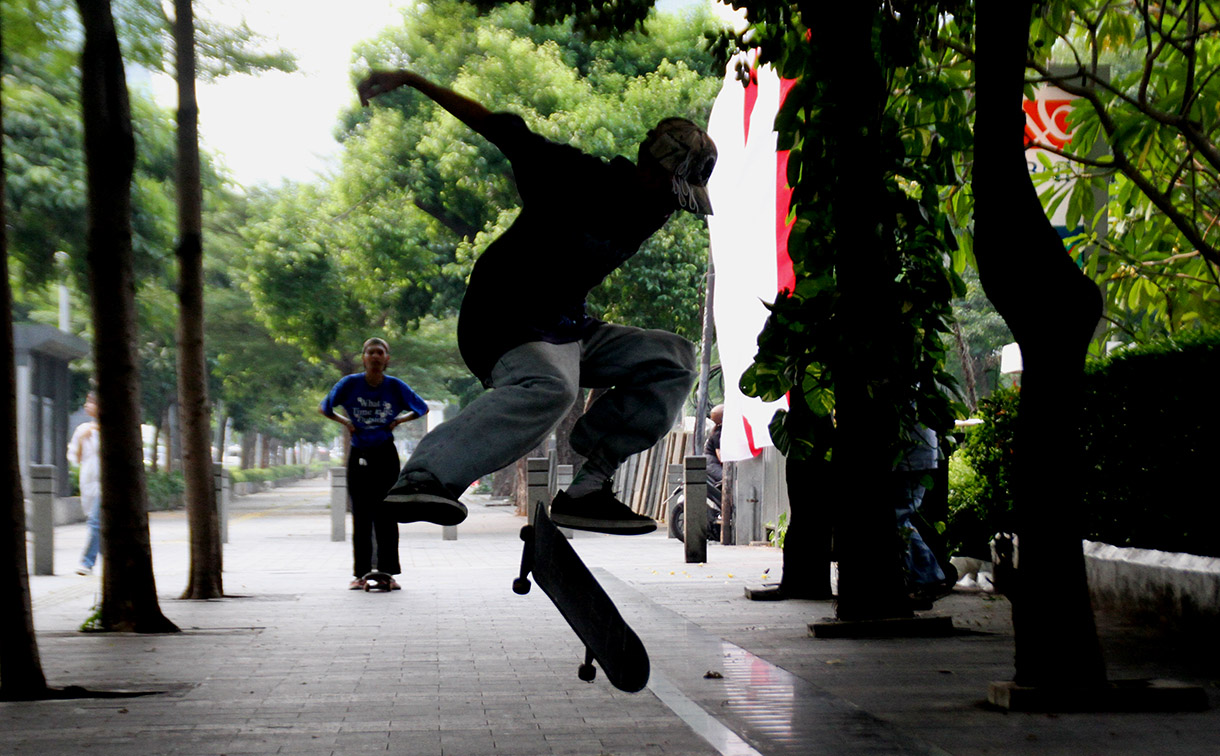 Seorang pemuda bermain skateboard di kawasan Sudirman, Jakarta, Minggu (28/7/2024).  (BeritaNasional.com/Oke Atmaja)