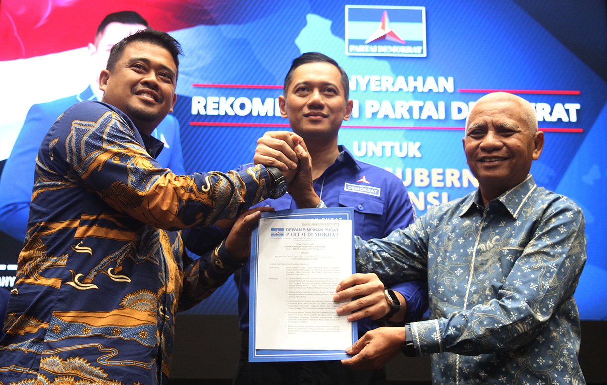 Ketua Umum DPP Partai Demokrat Agus Harimurti Yudhoyono (tengah) memberikan surat rekomendasi partai kepada bakal calon gubernur Muhammad Bobby Afif Nasution (kiri) dan bakal calon wakil gubernur Surya (kanan) untuk maju Pilkada Sumatra Utara 2024 di Kantor Partai Demokrat, Kamis (8/9/2024).  (BeritaNasional.com/Oke Atmaja)