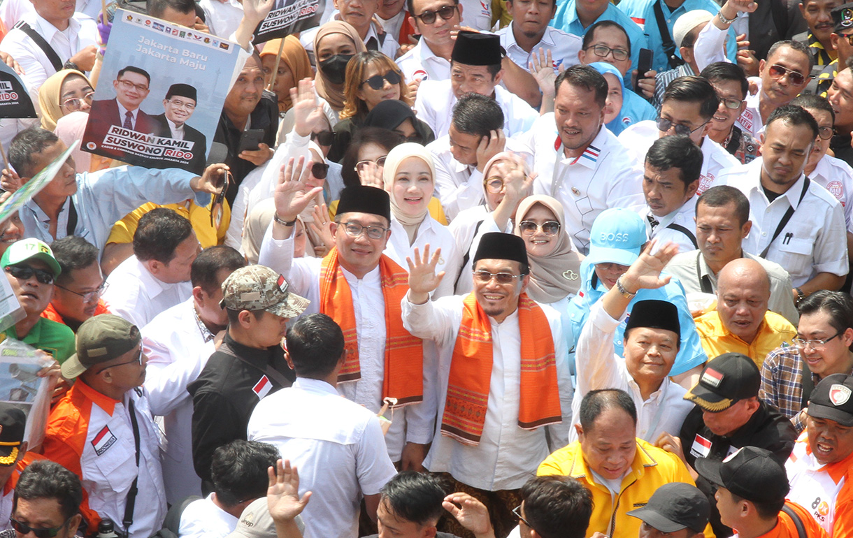 Pasangan bakal calon Gubernur DKI Jakarta Ridwan Kamil (tengah) dan bakal calon Wakil Gubernur DKI Jakarta Suswono menyapa warga dan para pendukung saat berjalan menuju Kantor KPU DKI Jakarta, Jalan Salemba Raya, Jakarta, Rabu (28/8/2024).(BeritaNasional.com/ Oke Atmaja)