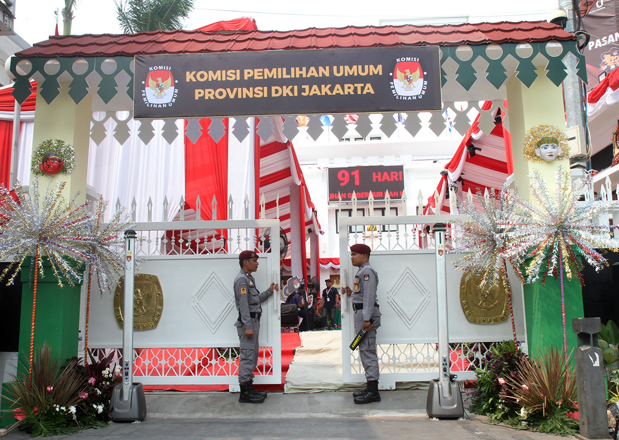 Petugas berjaga di pintu masuk Komisi Pemilihan Umum (KPU) DKI Jakarta pada hari pertama pendaftaran bakal calon gubernur dan wakil gubernur di Kantor KPU DKI Jakarta, Selasa (27/082024). (BeritaNasional.com/ Oke Atmaja)