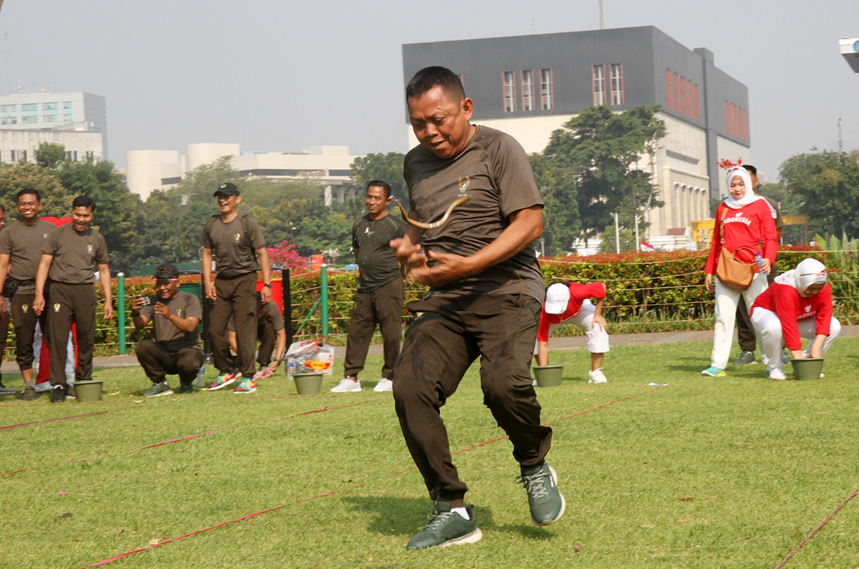 Peserta mengikuti lomba memasukan belut kedalam botol secara estafet dalam rangka memperingati HUT RI ke-79, di Silang Monas, Jakarta, Kamis (15/8/2024).  (BeritaNasional.com/ Oke Atmaja)