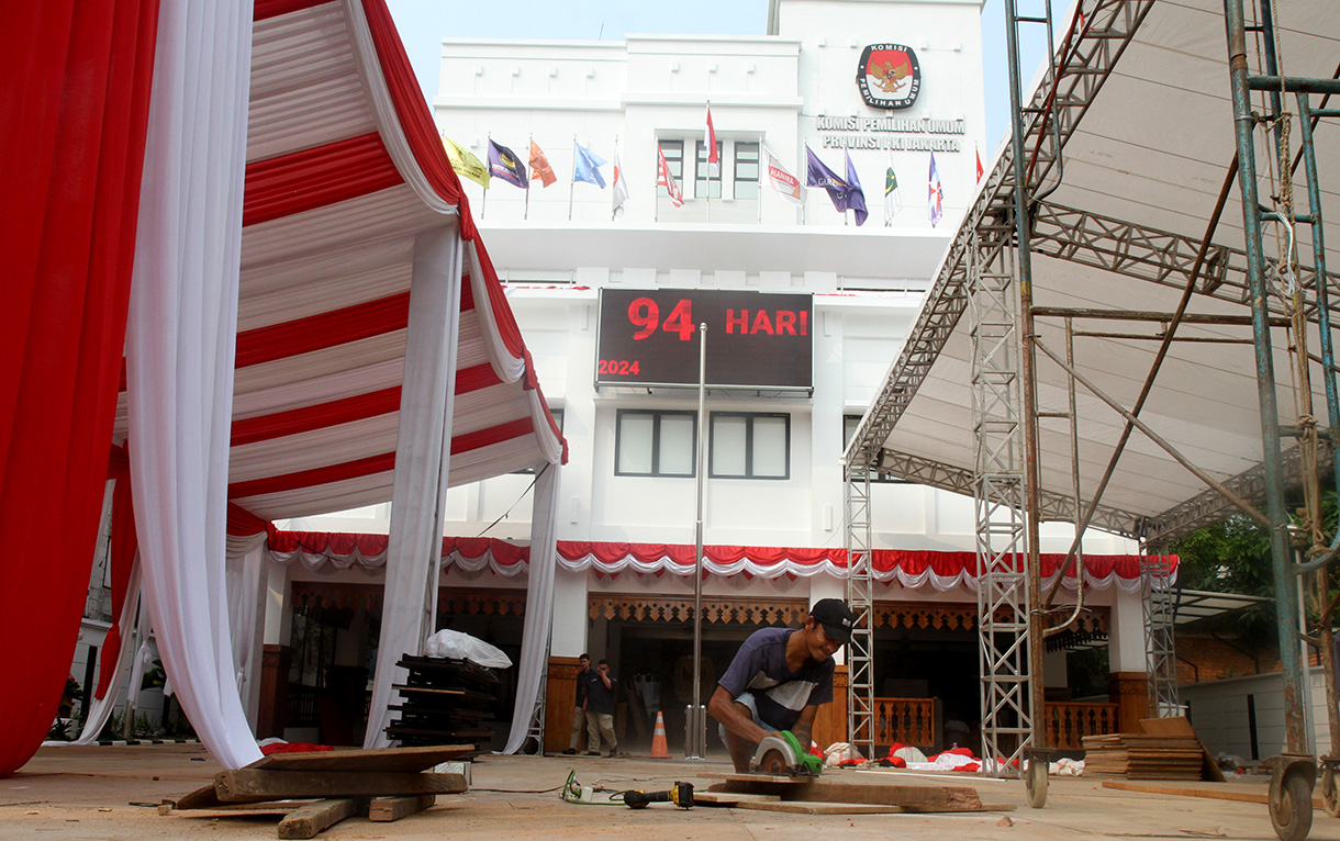 Pekerja memasang tirai di tiang tenda di kantor KPUD DKI Jakarta,Sabtu (24/8/2024). (BeritaNasional.com/ Oke Atmaja)