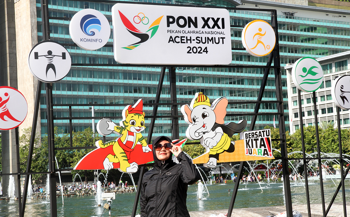 Warga berfoto berlatar belakang maskot PON XXI Tahun 2024 di Bundaran HI, Jakarta, Minggu (8/9/2024). (BeritaNasional.com/ Oke Atmaja)