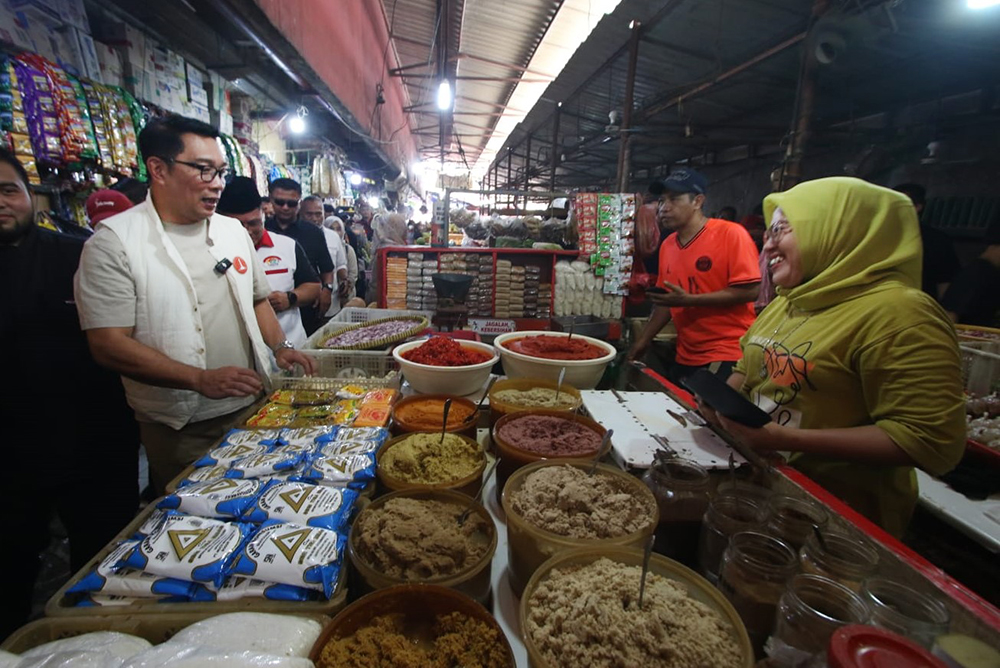 Cagub nomor urut 1 Ridwan Kamil (kiri) saat berbincang dengan pedagang di Pasar Kebayoran Lama. (BeritaNasional/Elvis Sendouw)