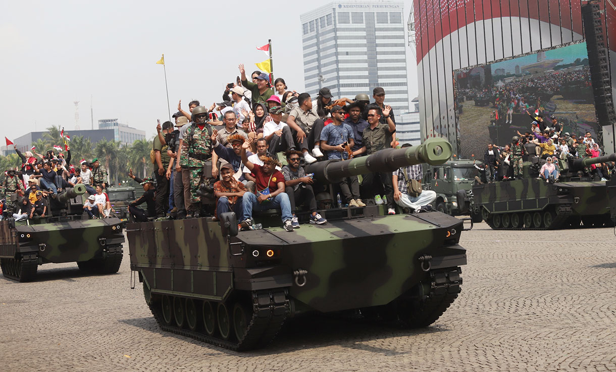 Sejumlah warga menaiki kendaraan tempur Tank Harimau TNI AD dalam perayaan Hari Ulang Tahun (HUT) ke-79 Tentara Nasional Indonesia (TNI) di Lapangan Silang Monumen Nasional (Monas), Gambir, Jakarta, Sabtu (5/10/2024). (BeritaNasional.com/Oke Atmaja)