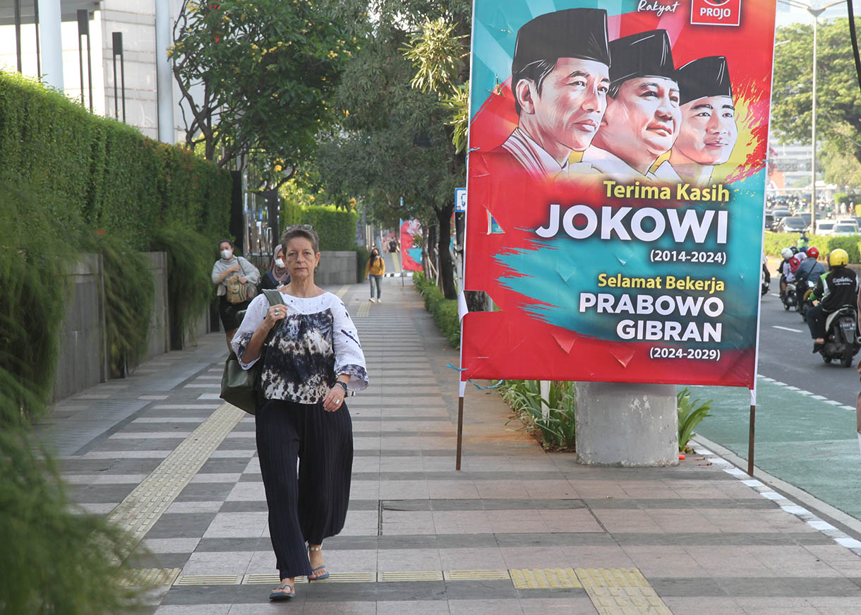 Warga berjalan di samping Baliho 'Terima Kasih Jokowi dan Selamat Bekerja Prabowo' di Jalan Jenderal Sudirman, Jakarta, Jumat (18/10/2024). (BeritaNasional.com/Oke Atmaja)