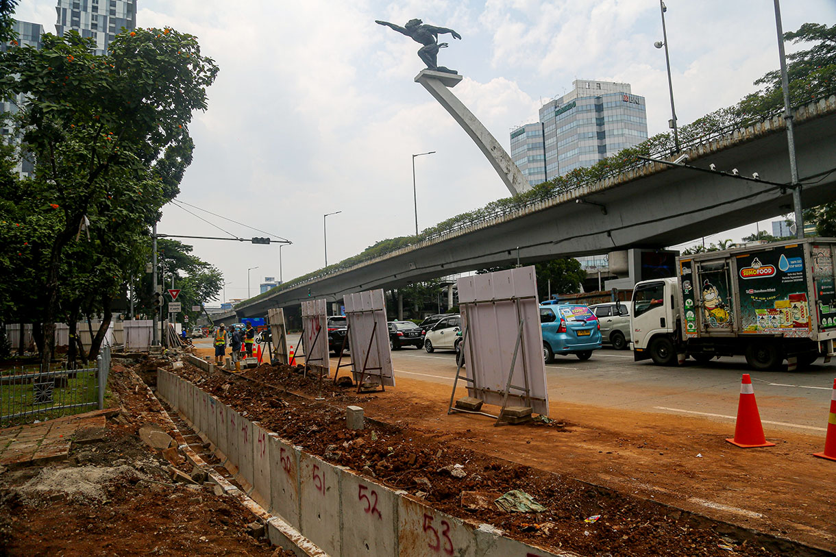 Pekerja menggunakan alat berat menyelesaikan perbaikan trotoar di Jalan Prof. DR. Soepomo, Jakarta, Rabu (9/10/2024).(BeritaNasional.com/Oke Atmaja)