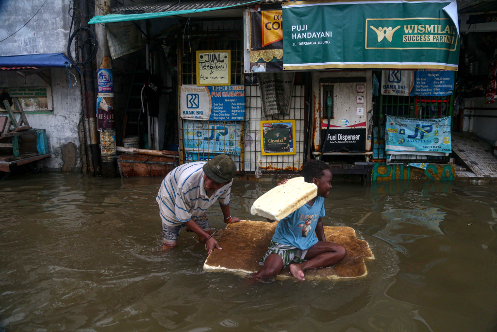 Sejumlah warga berjalan saat banjir rob di kawasan Muara Angke, Jakarta, Selasa (19/11/2024). (Berita Nasional.Com/Oke Atmaja)