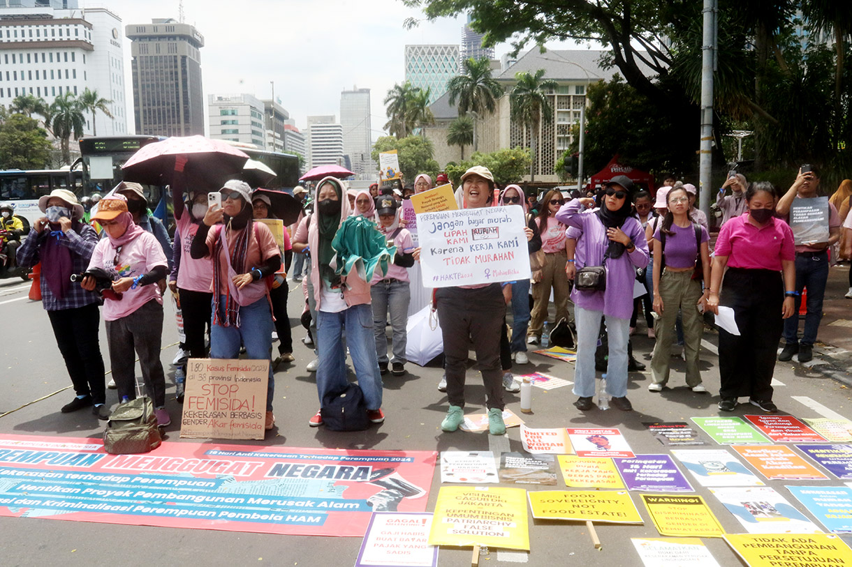 Sejumlah aktivis dari Aliansi Perempuan Indonesia (API) membawa poster dan spanduk dalam aksi damai Perempuan Menggugat Negara di Jalan MH. Thamrin, Jakarta, Senin (25/11/2024). (BeritaNasional.com/Oke Atmaja)