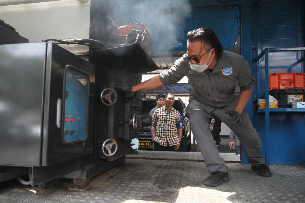 Petugas BNN memusnahan barang bukti narkotika di halaman parkir kantor BNN, Jakarta, Selasa (19/11/2024). BNN RI memusnahkan barang bukti narkotika berupa 20.221,35 gram atau 20 kilogram sabu dengan total sembilan orang tersangka hasil pengungkapan dari 2 kasus narkotika. (Berita Nasional.Com/Oke Atmaja)