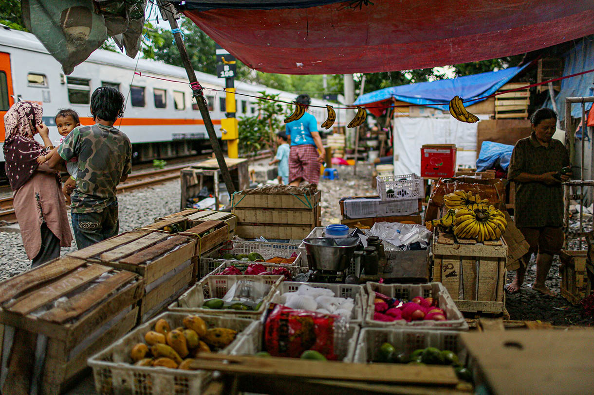 Pedagang menata dagangannya saat kereta api melintas yang berada Pasar Gaplok, lIntasan rel Kramat Sentiong-Pasar Senen kawasan Tanah Tinggi, Jakarta Pusat, Senin (11/11/2024).(BeritaNasional.com/Oke Atmaja)