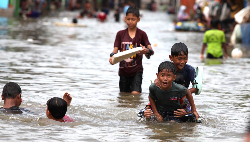 Sejumlah anak bermain di tengah banjir rob di Muara Angke, Jakarta, Senin (16/12/2024).  (Berita Nasional.com/Oke Atmaja)