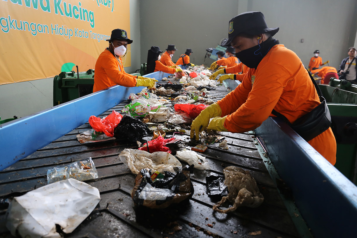 Pekerja merapikan sampah plastik yang telah dicacah menggunakan mesin pengolah sampah Refused Derived Fuel (RDF) di TPA Rawa Kucing, Kota Tangerang, Banten, Senin (9/12/2024).(BeritaNasional.com/Oke Atmaja)