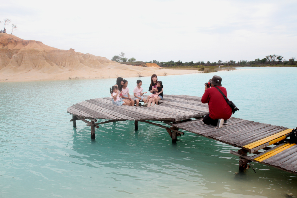 Wisatawan berfoto gurun pasir telaga biru  di Jalan Raya Busung, Kabupaten Bintan, Kepulauan Riau, Kamis (5/12/2024). (Berita Nasional.com/Oke Atmaja)