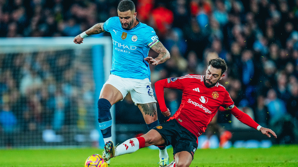 Pemain Man United Bruno Fernandes menekel bek Man City Kyle Walker. (Foto/mancity.com)