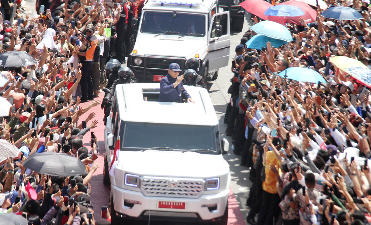 Presiden Prabowo Subianto berdiri menyapa warga dari mobil Pindad Maung Garuda saat tiba di Istana Merdeka, Jakarta, Minggu (20/10/2024).(BeritaNasional.com/Oke Atmaja)