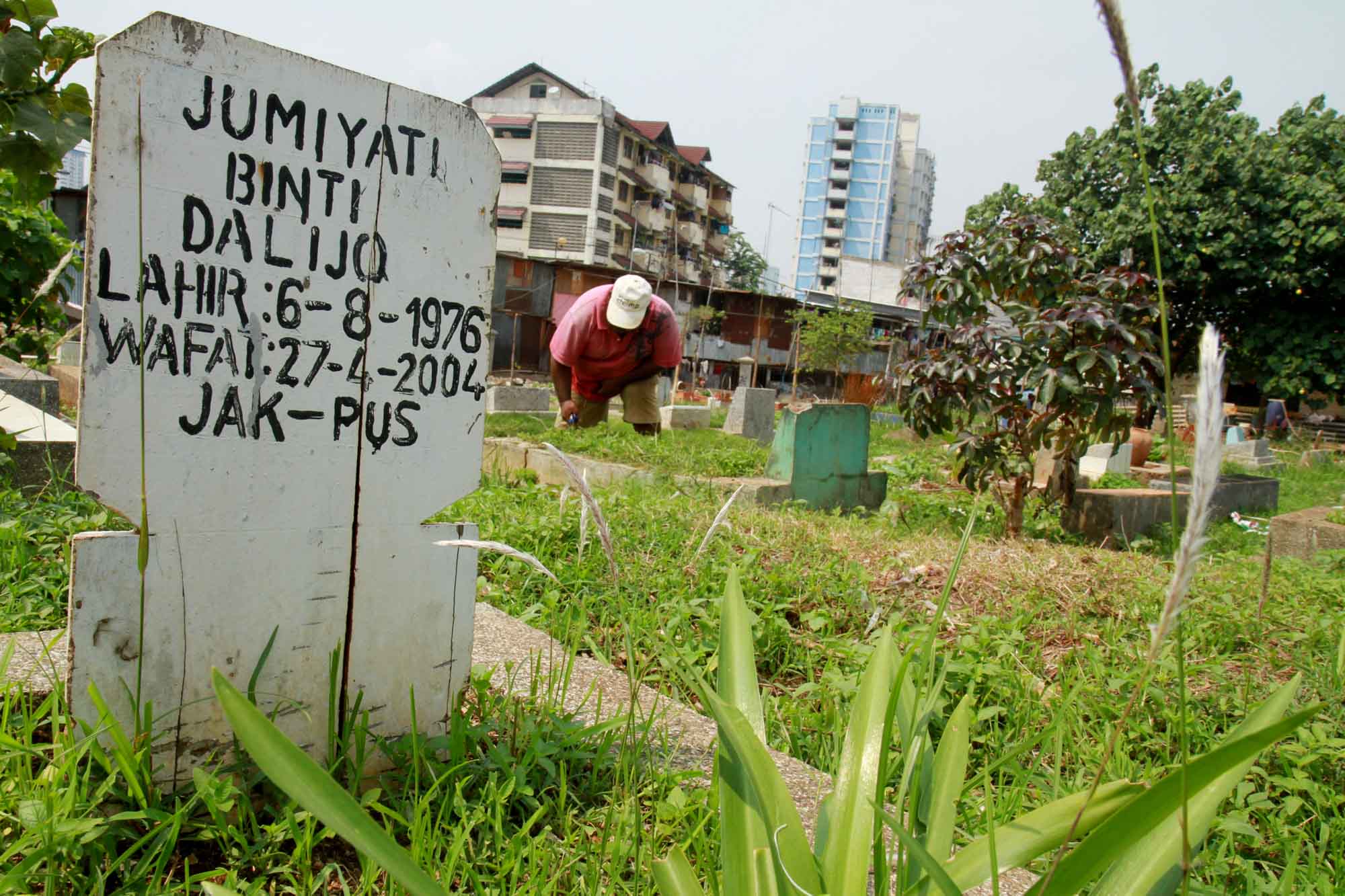 Petugas pemakaman membersihkan makam dan di Tempat Pemakaman Umum (TPU) Karet Bivak, Tanah Abang, Jakarta Pusat, Rabu (11/12/2024).(BeritaNasional.com/Oke Atmaja)