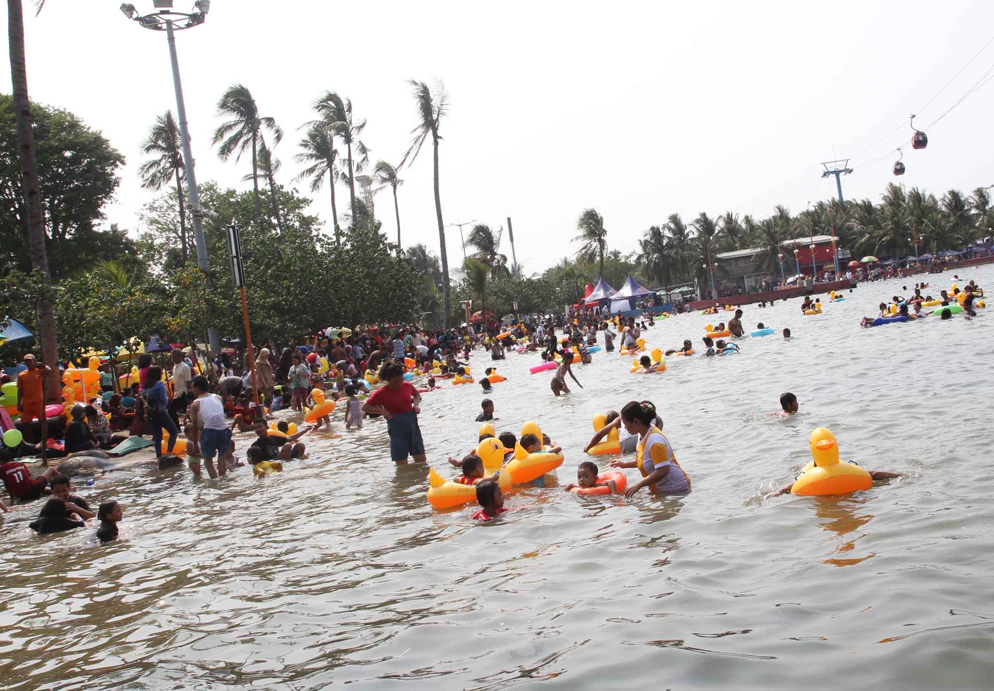 Pengunjung berwisata di Pantai Ancol Taman Impian, Jakarta, Jumat (27/12/2024).(BeritaNasional.com/Oke Atmaja)