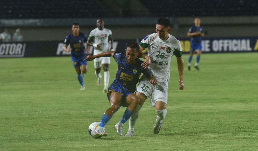 Penyerang Persib Beckham Putra Nugraha (kiri) dikawal ketat pemain Zhejiang FC pada pertandingan grup F ACL 2 di Stadion Si Jalak Harupat, Kabupaten Bandung. (Foto/Persib.co.id)