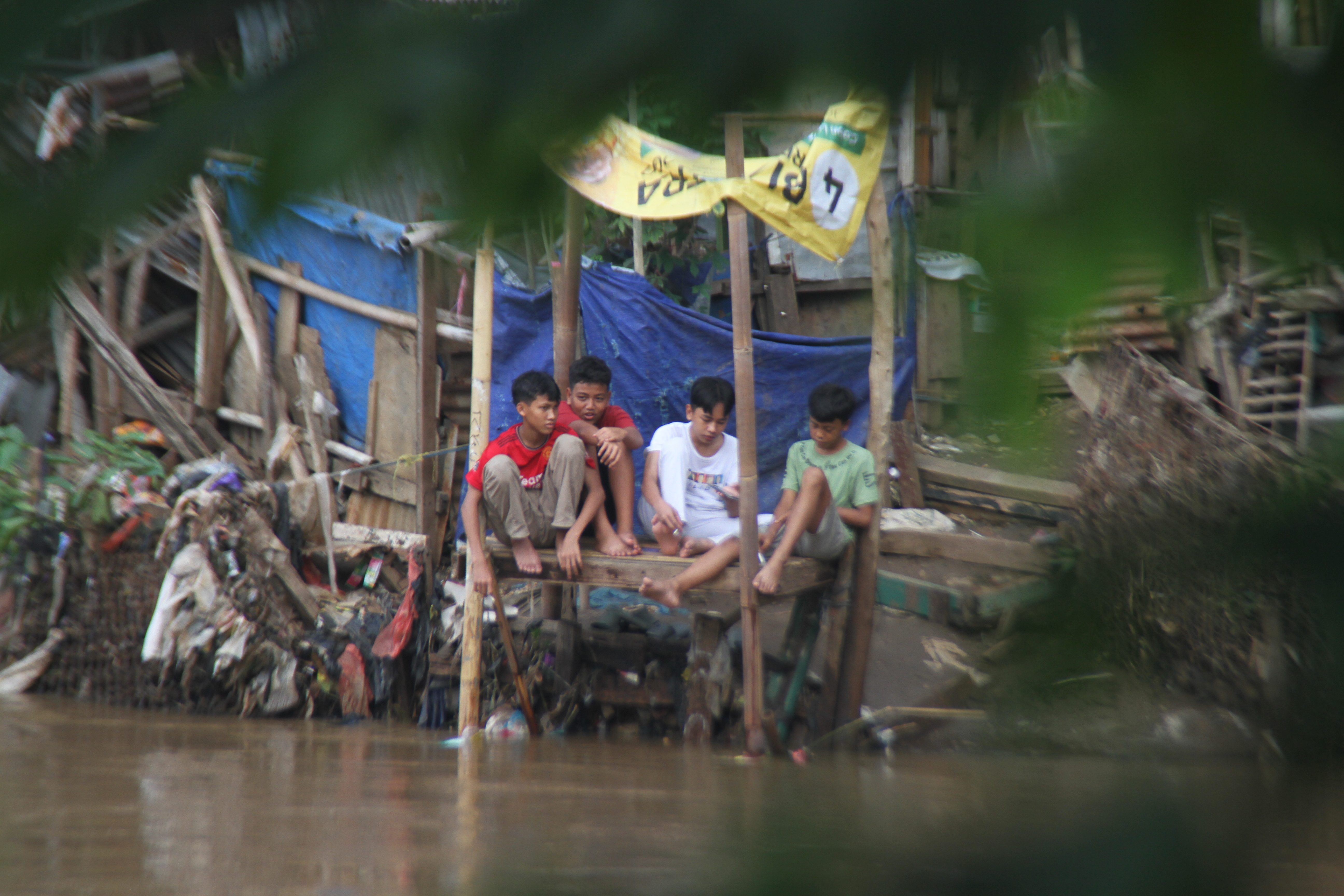 Warga beraktivitas di bantaran Sungai Ciliwung dekat Stasiun Manggarai, Jakarta, Jumat (13/12/2024).(BeritaNasional.com/Oke Atmaja)