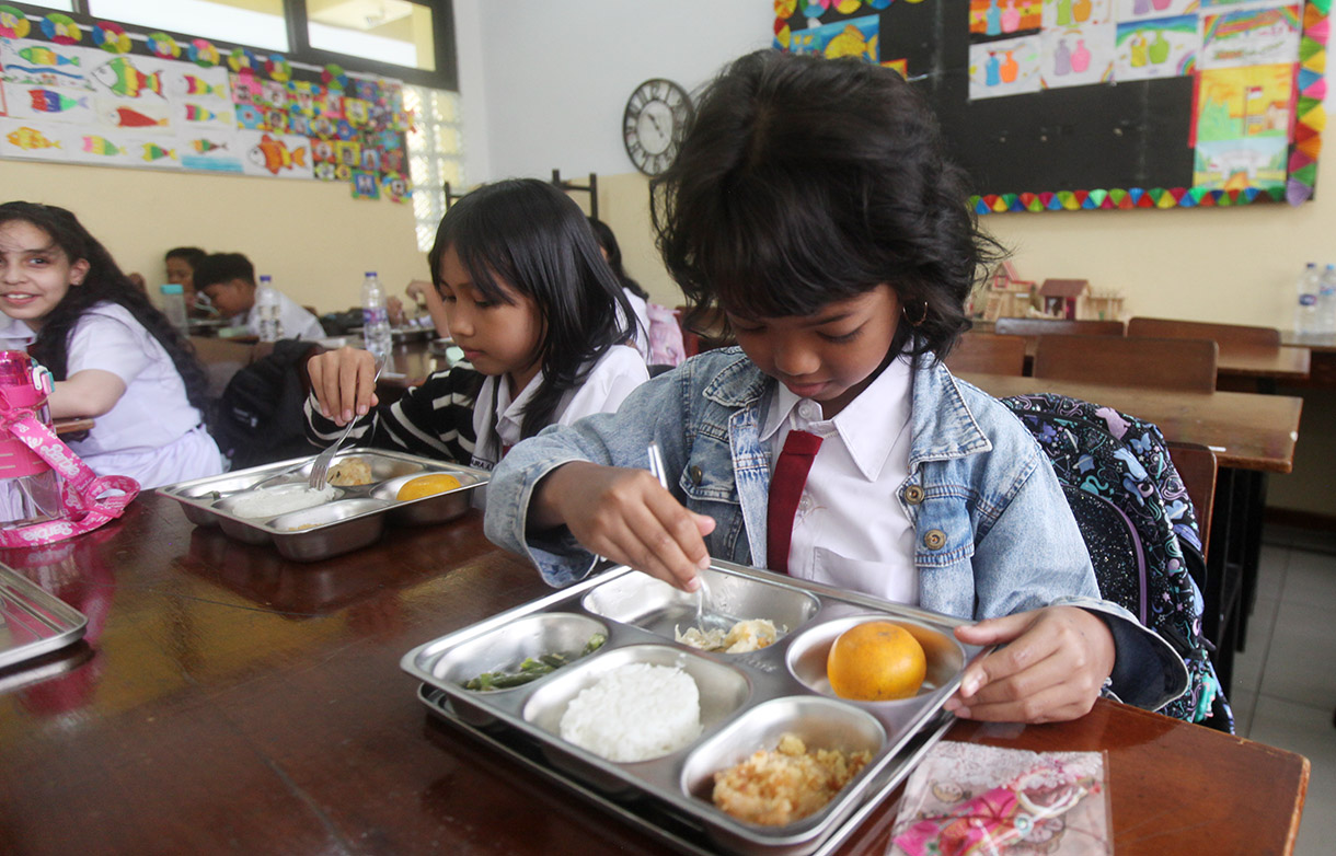 Murid menyantap makanan bergizi gratis di SD Barunawati Slipi, Jakarta, pada Senin (6/1/2025). (BeritaNasional/Oke Atmaja)