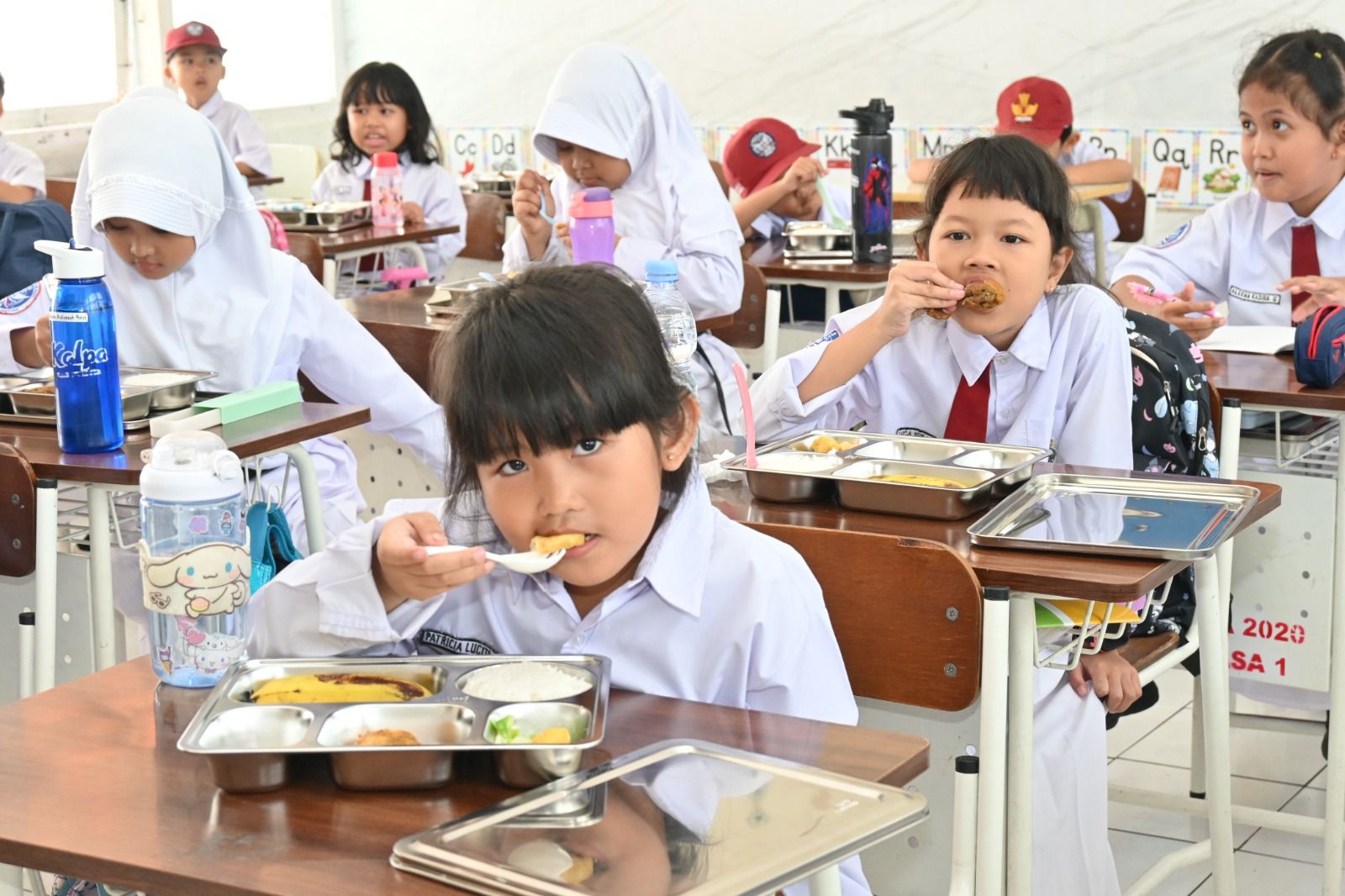 Anak SD menyantap makanan MBG (BeritaNasional/Istimewa)