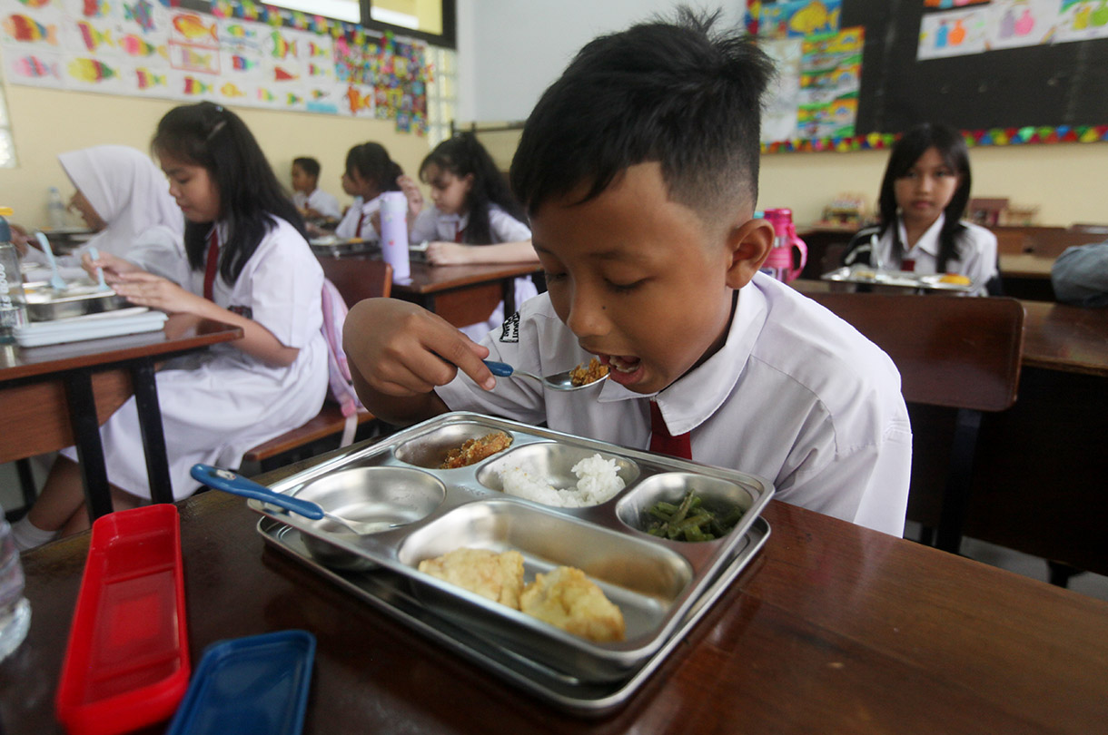 Murid menyantap makanan bergizi gratis di SD Barunawati  Slipi, Jakarta, Senin (6/1/2025).(BeritaNasional.com/Oke Atmaja)