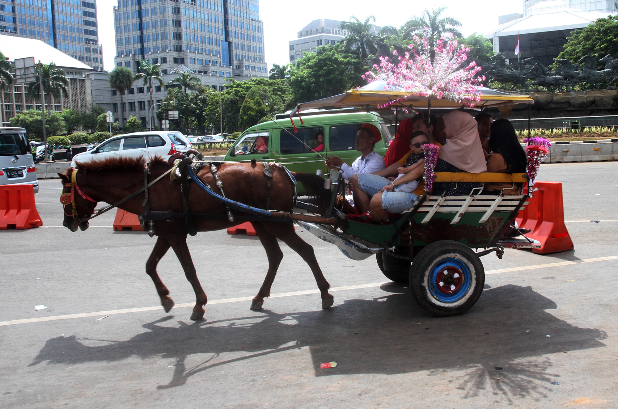 Warga berkeliling dengan delman di kawasan IRTI Monas, Jakarta, Rabu (01/01/2024).(BeritaNasional.com/Oke Atmaja)