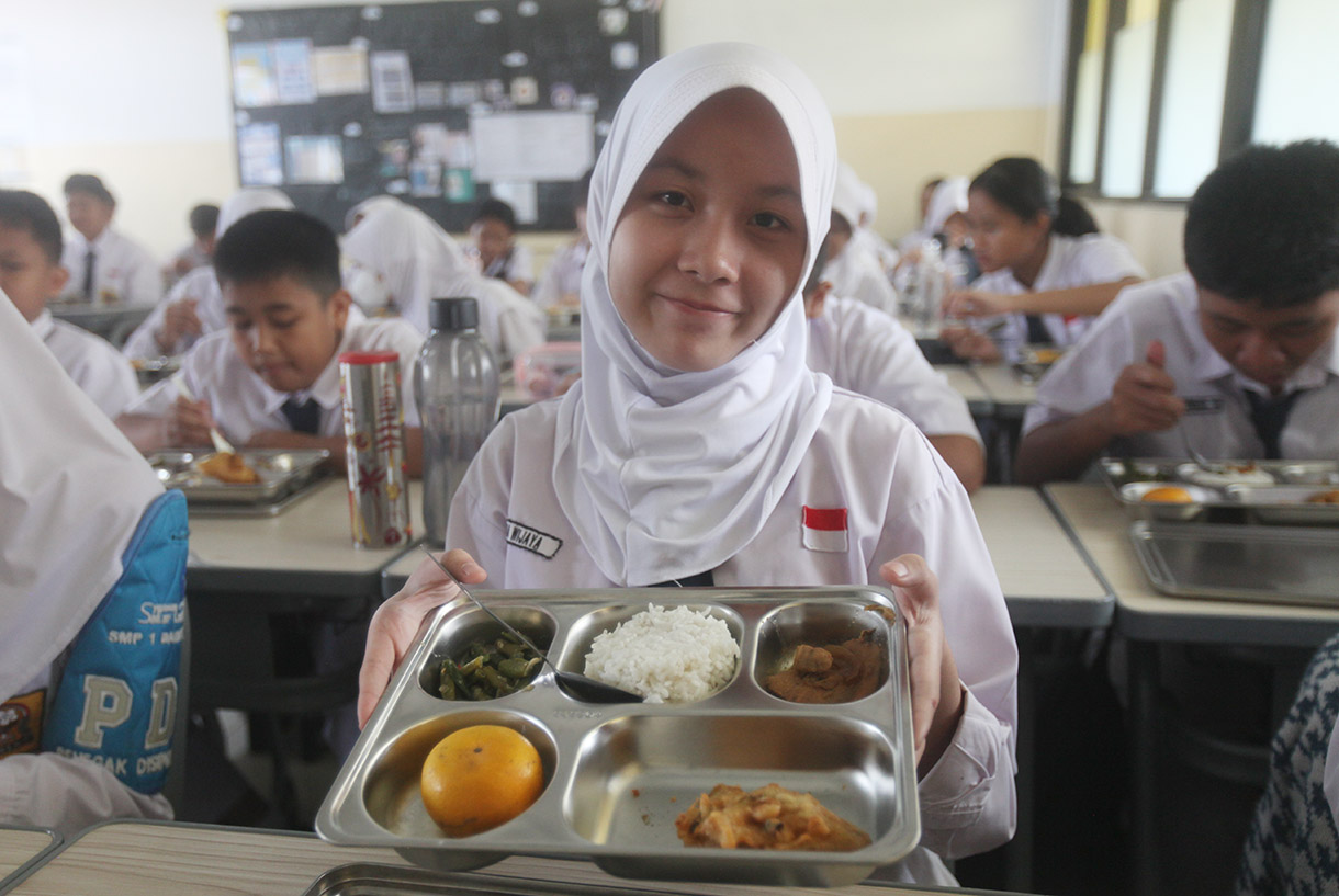 Siswa menyantap makanan bergizi gratis di SMP Barunawati Slipi, Jakarta, Senin (6/1/2025).(BeritaNasional.com/Oke Atmaja)