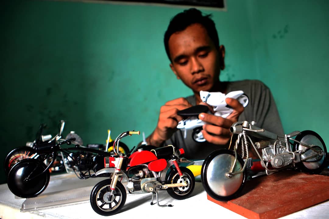 Perajin menyelesaikan pembuatan miniatur motor kastem dari barang bekas. (BeritaNasional/Elvis Sendouw)