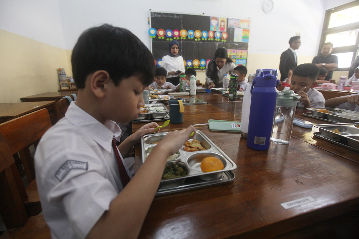 Murid menyantap makanan bergizi gratis di SD Barunawati Slipi, Jakarta, Senin (6/1/2025).(BeritaNasional.com/Oke Atmaja)