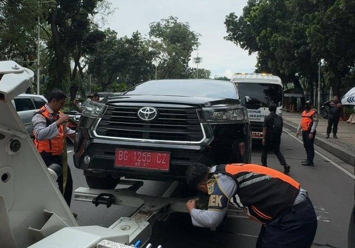 Petugas Dishub menderek mobil yang parkir sembarangan di kawasan Monas. (Foto/Istimewa).