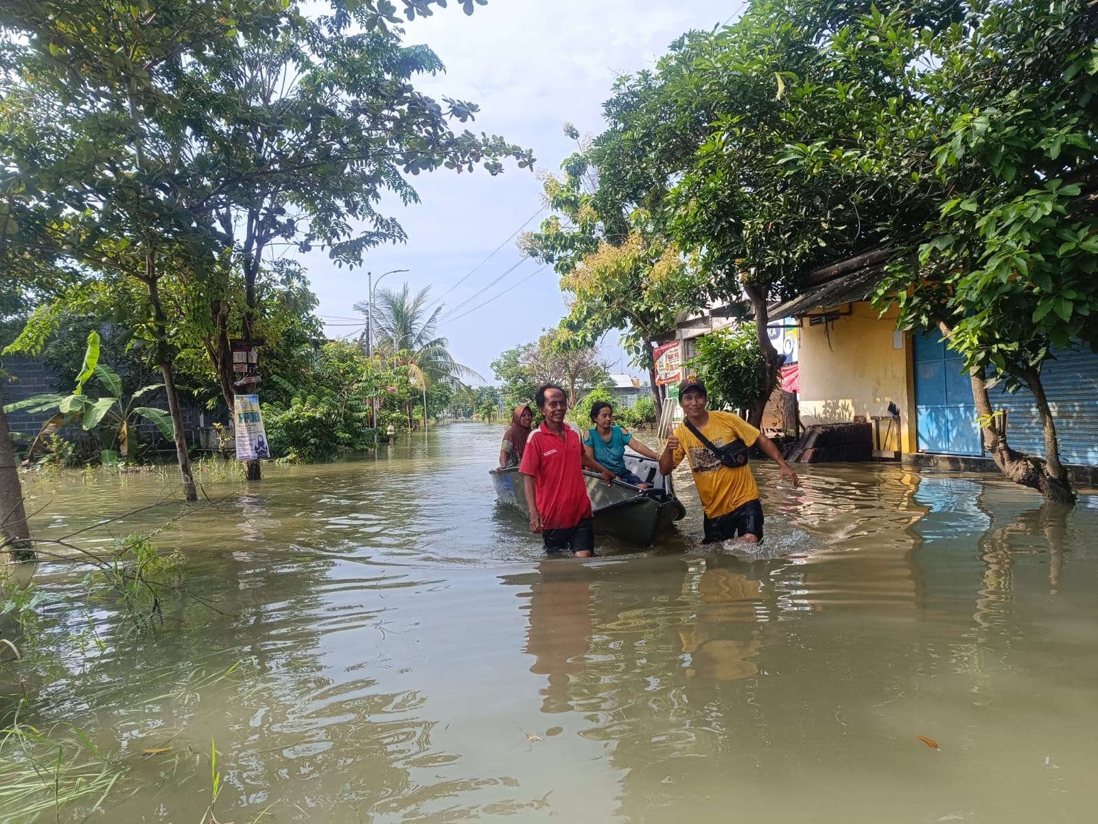 Warga evakuasi wanita yang terdampak banjir di Gresik Jawa Timur menggunakan perahu. (BeritaNasional/BNPB)