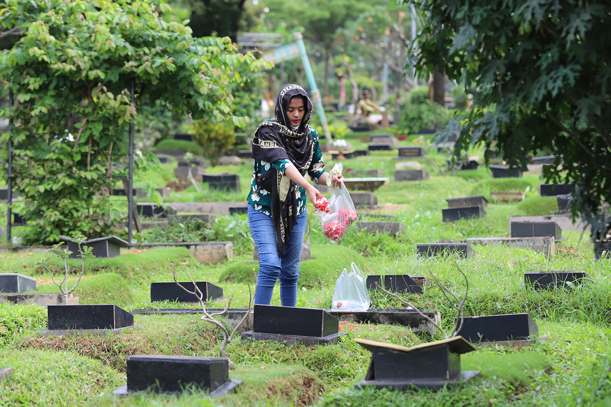 Sejumlah warga berdoa menaburkan bunga di makam keluarganya di tempat pemakaman umum Karet Bivak,Jakarta, Jumat(28/2/2025). (Beritanasional.com/Oke Atmaja)