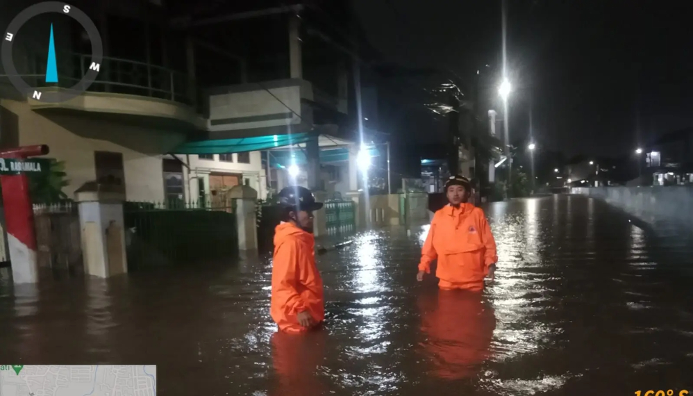 Anggota BPBD Tangsel sedang menerjang banjir untuk mengevakuasi korban. (Foto/BNPB)