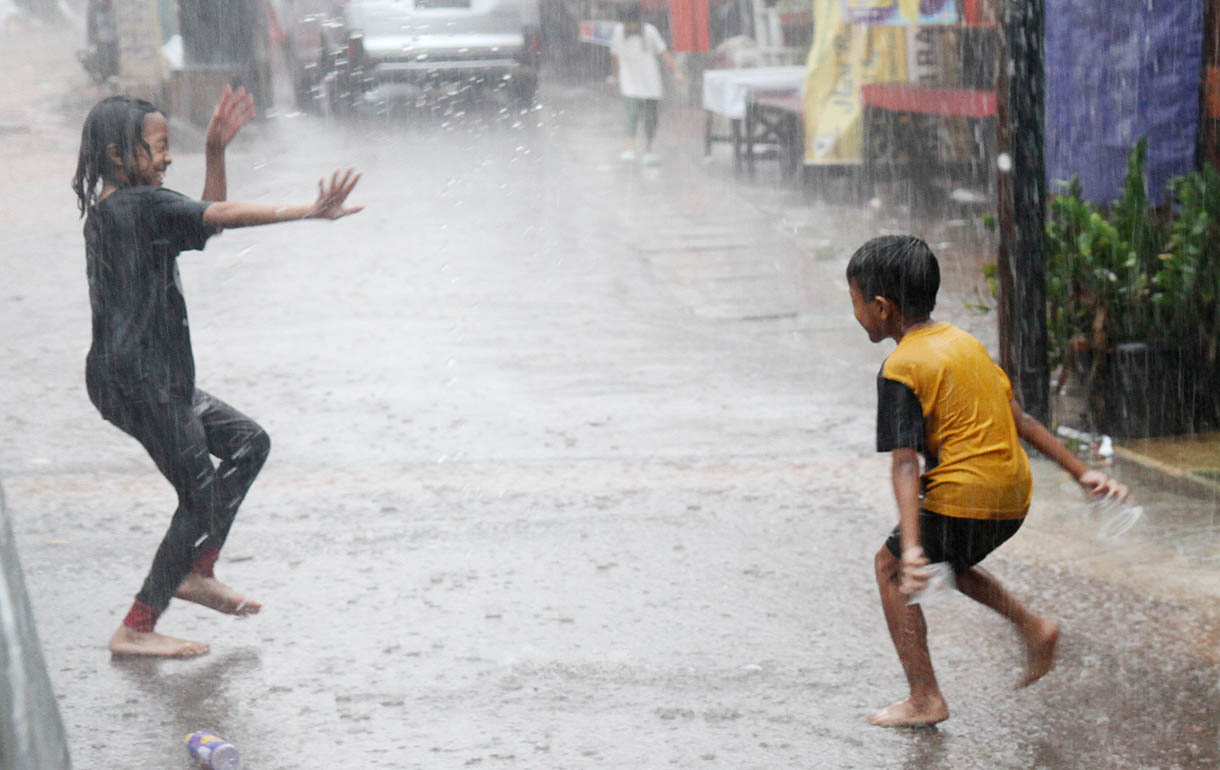 Anak-anak main di bawah guyuran hujan (BeritaNasional/Oke Atmaja)